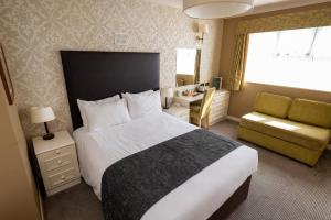 SibsonMillers Hotel by Greene King Inns的酒店客房带一张大床和一把椅子