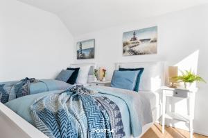 奥尔本尼兹Port Seven的卧室拥有白色的墙壁和蓝色床单。