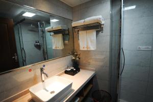 涪陵重庆建峰宾馆的一间带水槽、淋浴和镜子的浴室