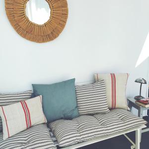 巴达霍斯La Zagala的沙发、枕头和墙上的镜子