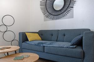 里摩日Le pied à terre d'ernest的客厅配有蓝色沙发,设有镜子