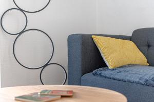 里摩日Le pied à terre d'ernest的蓝色的沙发,配有黄色枕头和桌子