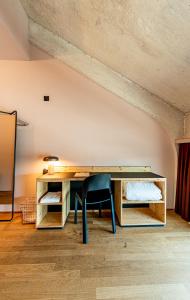 巴塞尔Silo Design & Boutique Hostel Basel的一张木桌,椅子放在房间里