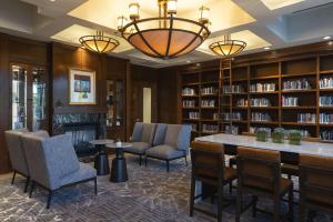 克拉尔维尔科勒尔维尔会议中心万豪酒店的图书馆配有椅子、桌子和书架