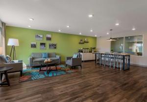 罗阿诺WoodSpring Suites Roanoke的客厅以及带沙发和桌子的厨房。