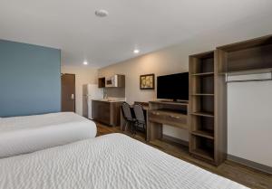 罗阿诺WoodSpring Suites Roanoke的酒店客房设有两张床和一张带电脑的书桌