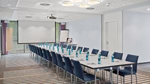腓特烈港Hey Lou Hotel Friedrichshafen的一间会议室,配有长桌子和蓝色椅子