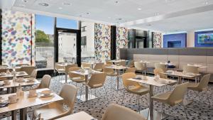 腓特烈港Hey Lou Hotel Friedrichshafen的用餐室设有桌椅和窗户。