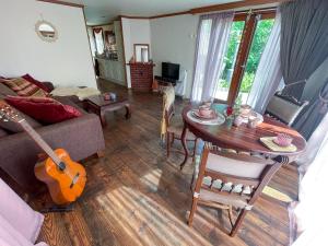 福尔特赫伊曾Boschalet Magnolia的客厅配有沙发和带吉他桌的桌子