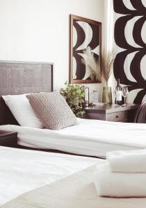 海门林纳艾米利亚酒店的卧室配有2张白色的床和桌子