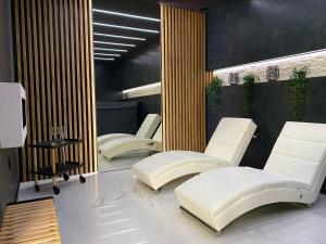 斯塔拉·里斯拉Vila GARUFA Wellness & Spa的一间设有三把白色椅子和一张桌子的房间