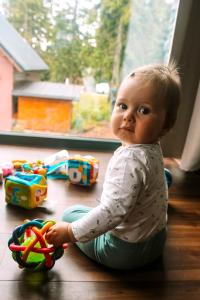 马丁斯克霍尔Chata MartinSki Martinske hole的坐在地板上的婴儿玩玩具