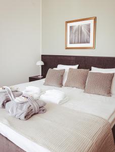 海门林纳艾米利亚酒店的一张配有白色床单和枕头的大床