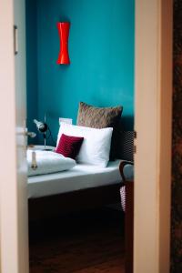 文西德尔Molo Rouge的蓝色的客房配有带枕头的长凳和红灯。