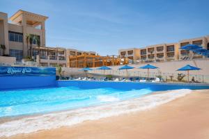 沙姆沙伊赫Cleopatra Luxury Resort Sharm - Adults Only 16 years plus的海滩旁的游泳池,配有蓝伞