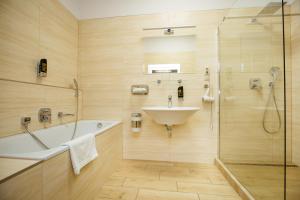 科马尔诺立托维尔酒店的带浴缸、水槽和淋浴的浴室