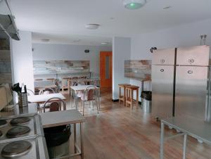 贝尔法斯特贝尔法斯特国际青年旅舍的带桌椅的房间和带冰柜的厨房