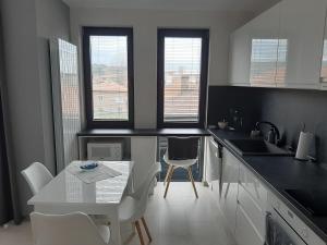 卡赞勒克Апартамент ДОРА的厨房配有桌子和白色的桌椅