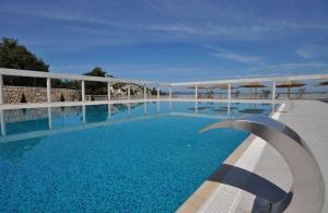 德拉格Premium mobile home Maslina - Oaza mira的一座带蓝色水和遮阳伞的大型游泳池