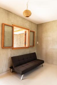 加夫多斯岛Exoristoi Nature Suites的窗户房间里一张黑色的沙发