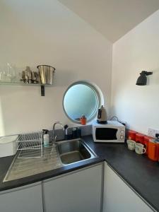 洛斯特威希尔Little Breoke的厨房柜台设有水槽和镜子