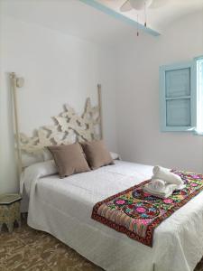 佩德罗－贝尔纳多La casa de tío Vidal的卧室配有一张白色的床,床上有毯子
