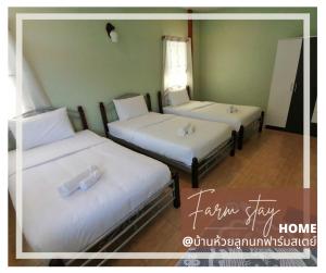 拉差汶里บ้านห้วยลูกนกฟาร์มสเตย์ Banhuailuknok Farmstay的配有白色床单的客房内的两张床