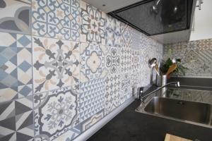 大塔拉哈尔Casa Playa Chica的一间带水槽和瓷砖墙的厨房