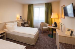 开姆尼茨开姆尼茨公园琥珀酒店的配有一张床和一张书桌的酒店客房