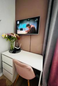 利沃夫Iren Smart Apartment的一张白色的桌子,墙上配有电视