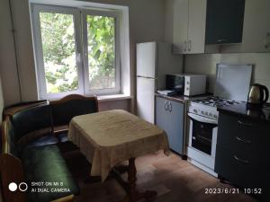 第聂伯罗Квартира на Агнии Барто的厨房配有白色冰箱和桌子