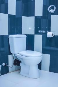 尼甘布Royal Hub的浴室铺有蓝色瓷砖,设有白色卫生间。
