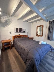 拉安戈斯图拉镇Portal del Manzano的一间卧室配有一张带蓝色毯子的大床