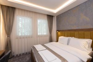 新帕扎尔Hotel M Star Novi Pazar的一间卧室设有一张大床和一个窗户。