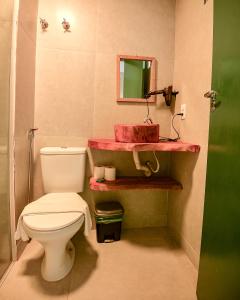 马拉戈日Cocco Pousada的浴室设有白色卫生间和红色盥洗盆。