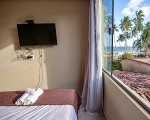马拉戈日Cocco Pousada的客房设有电视、床和窗户。