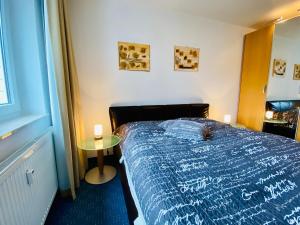 黑灵斯多夫Haus Nemo - Ferienwohnung 10的一间卧室配有一张床和一张小桌子