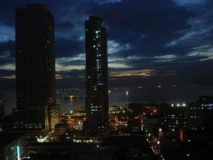 马尼拉Condo in Ermita Manila, Near US Embassy, Mall and Parks with Excellent View的城市天际线,夜晚有高楼