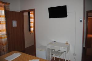 GuardialfieraHotel Ristorante Solelago的一间设有一张桌子和一台墙上的电视的房间