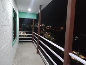 巴德里纳特Badrinath Jb Laxmi hotel的阳台,晚上可欣赏到城市景观