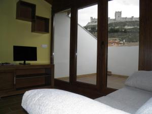 佩纳菲尔Apartamentos Turísticos Peñafiel的一间卧室设有享有城堡景致的窗户。