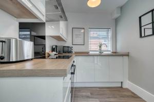 诺丁汉Stylish Home - Fast Wi-Fi-FREE Parking的厨房配有白色橱柜和不锈钢用具