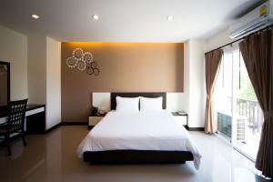 罗勇Phavina Hotel Rayong SHA Extra Plus的一间卧室设有一张床和一个大窗户