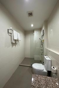 罗勇Phavina Hotel Rayong SHA Extra Plus的白色的浴室设有卫生间和淋浴。