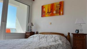 古瓦伊Kagiabis' Home的卧室配有一张床,墙上挂有绘画作品
