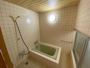 Muraokakakayama hutte的角落处设有带浴缸的浴室。