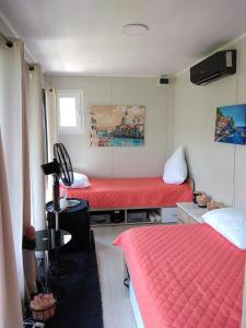 阿尔杰什河畔库尔泰亚Glamping pe Drum Transfagarasan srl的一间设有两张红色床单的床的房间
