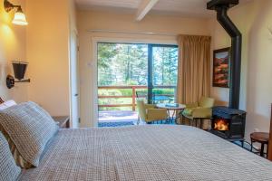 Little RiverInn at Buckhorn Cove的一间卧室设有一张带壁炉的床和一个阳台。