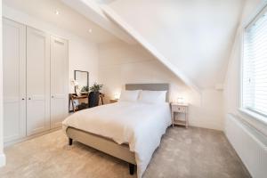 霍伊莱克2 The Quadrant Luxury Apartments - Hoylake的白色的卧室设有床和窗户