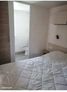 雷日卡普费雷sweet mobil-home的卧室配有白色的床和镜子